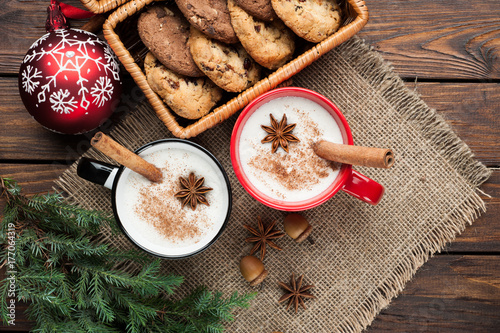 eggnog cocktail in  mug arranged with christmas decoration and cookies box on wooden table