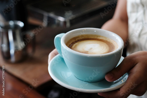 Woman hands holding green coffee cup at cafe background  close up  food and drinks concept