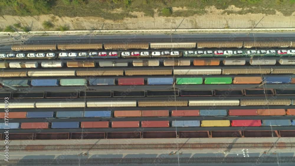AERIAL TOP DOWN: Flying above industrial railroad station with cargo trains and freight containers on sunny day. Fully loaded railroads and shipping container trains on industrial railway terminal. AERIAL TOP DOWN: Flying above industrial railroad station with cargo trains and freight containers on sunny day. Fully loaded railroads and shipping container trains on industrial railway terminal.