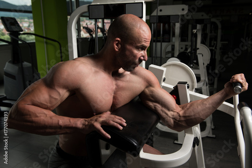 Man On Machine Exercising Biceps