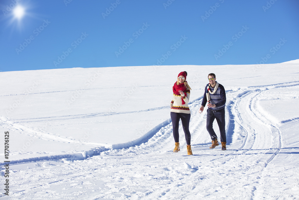 Carefree happy young couple having fun together in snow.