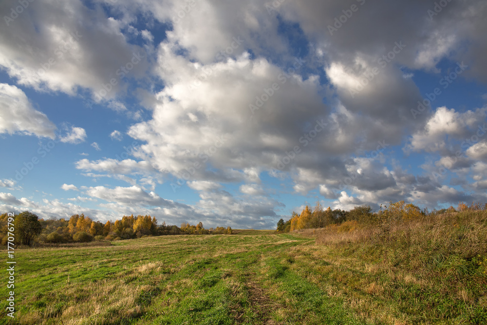 Colorful autumn landscape with a field in hilly terrain. Evening. The sky with heavy white clouds. Picture, Wallpapers, calendar. Colorful autumn landscape with a field in hilly terrain. Evening. The sky with heavy white clouds. Picture, Wallpapers, calendar.