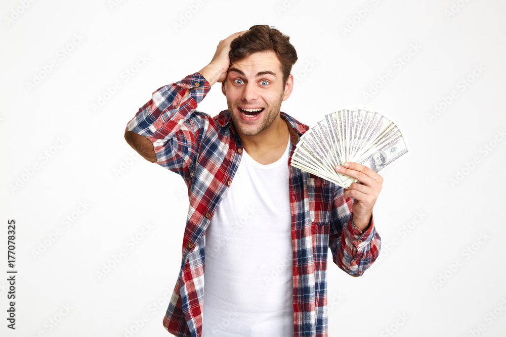 Portrait of a overwhelmed excited man holding bunch of money Portrait of a overwhelmed excited man holding bunch of money