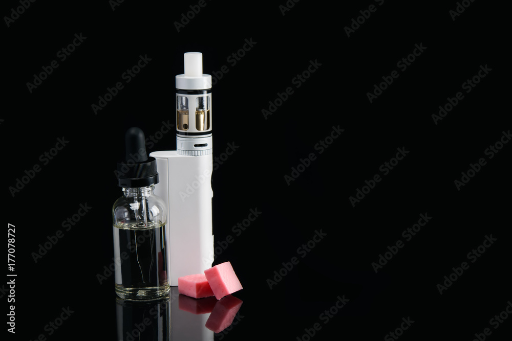 electronic cigarette stands on a black background, and two pink chewy candy electronic cigarette stands on a black background, and two pink chewy candy