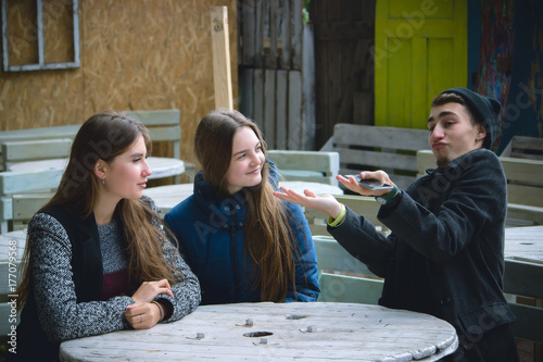 Group of friends meeting In the local Coffee Shop. Young man try to explain something
