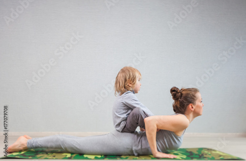 hatha yoga exercises mom with child practicing at home