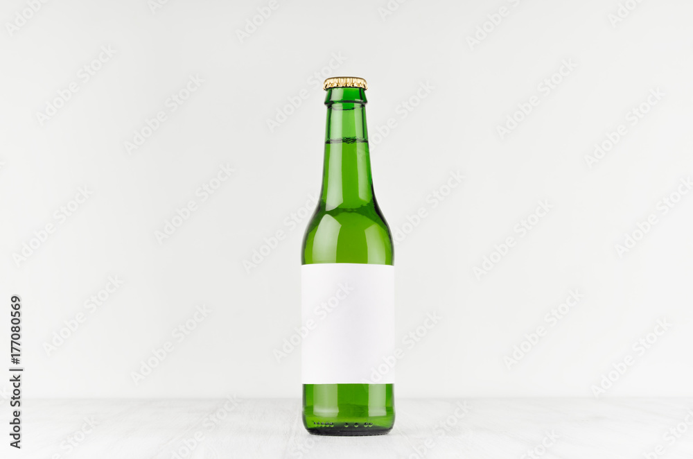 Green longneck beer bottle 330ml with blank white label on white wooden board, mock up. Template for advertising, design, branding identity. Green longneck beer bottle 330ml with blank white label on white wooden board, mock up. Template for advertising, design, branding identity.