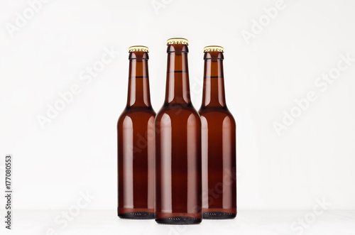 Group brown longneck beer bottle 330ml mock up. Template for advertising, design, branding identity on white wood table.