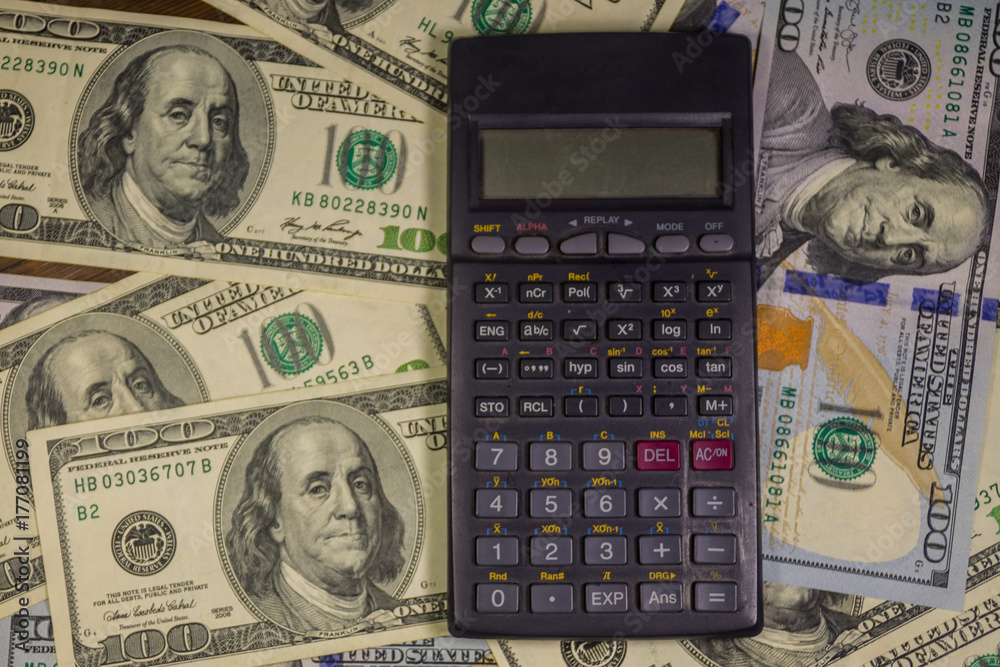 Calculator on the American one hundred dollar bills background Calculator on the American one hundred dollar bills background