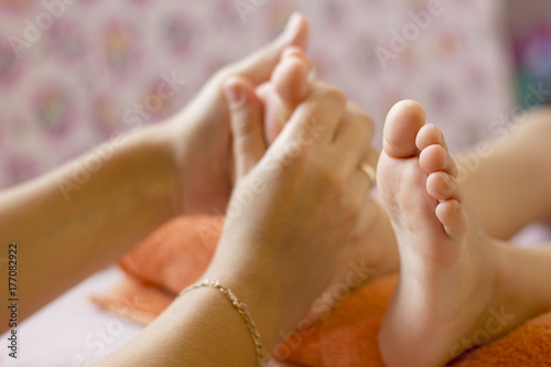 female hands doing massage of feet child