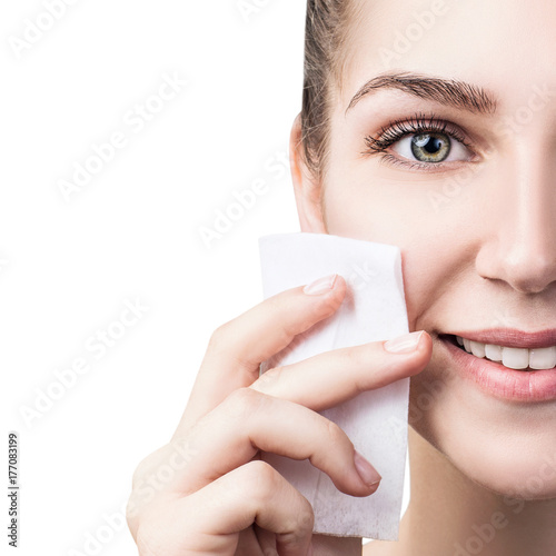 Foto Young woman cleaning her face by napkins.