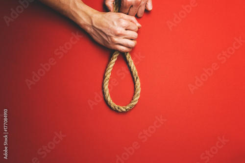 The man tightens the noose