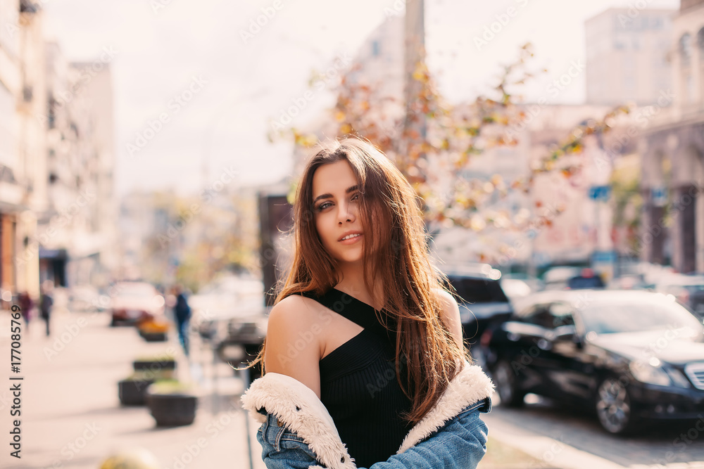 Stylish hipster girl in the retro jeans suit posing in the street