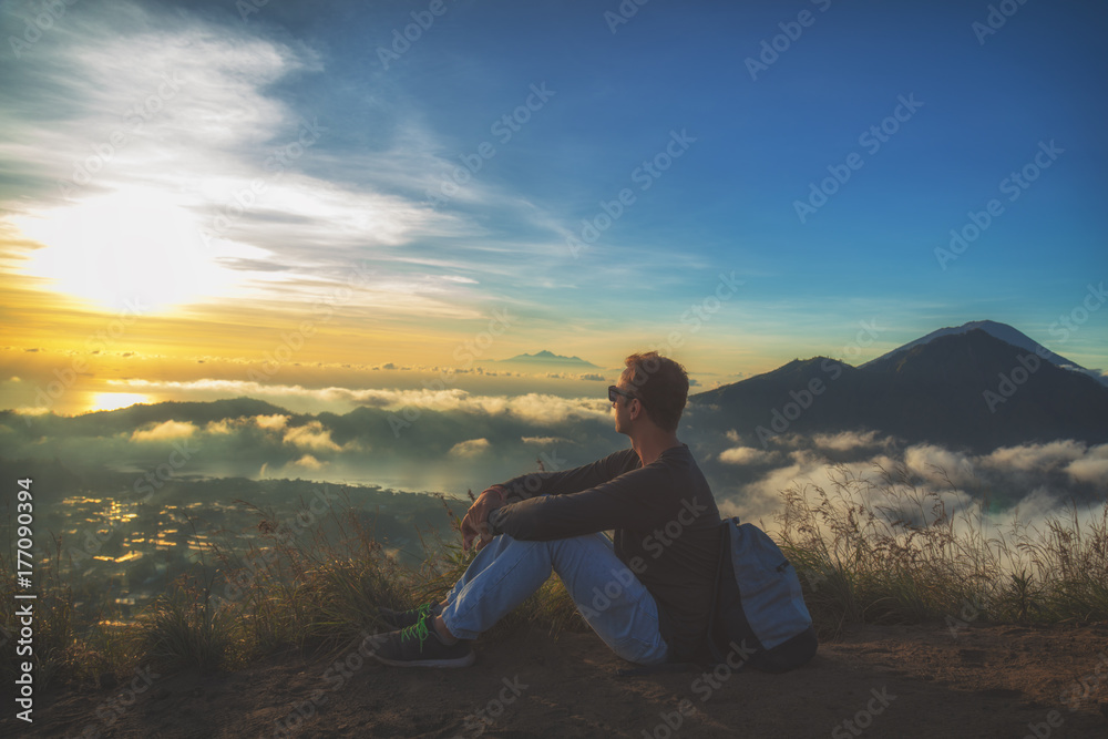 Man watching the sunrise from mount Batur, Bali - Indonesia.