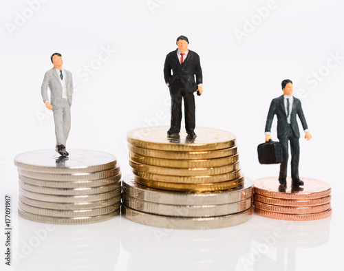 Miniature business people stand on money coins isolated on white,Business competition winner concept