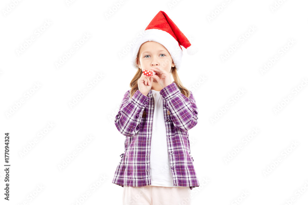 Portrait of sweet little girl in Santa hat blowing into party blower Portrait of sweet little girl in Santa hat blowing into party blower