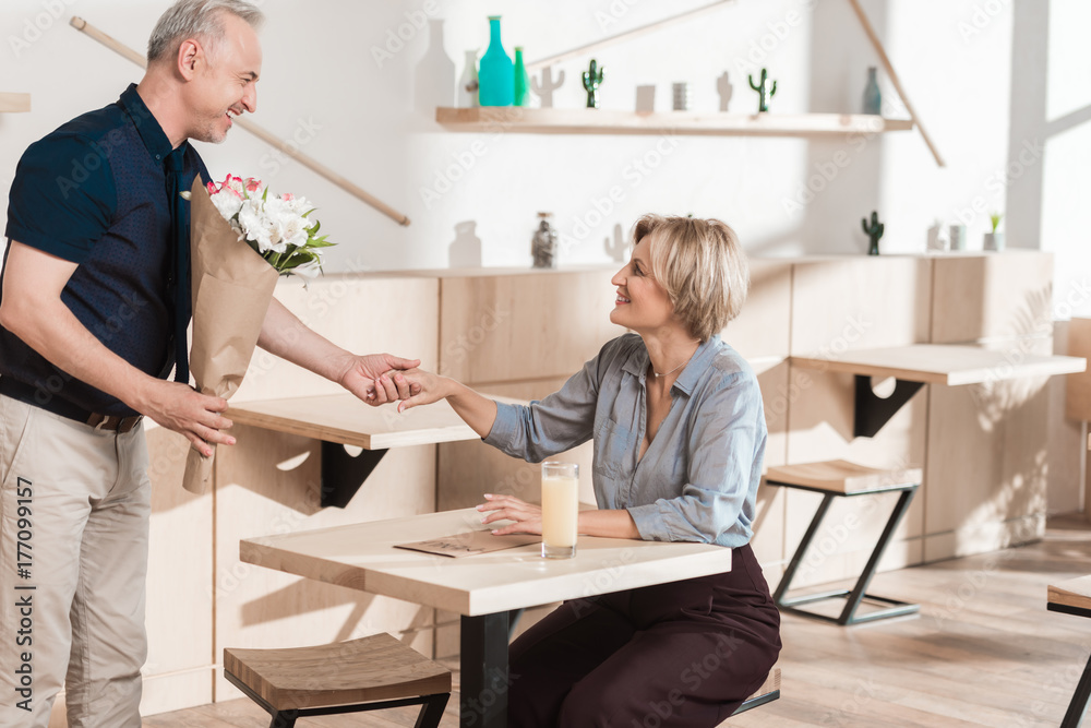 Man presenting bouquet of flowers to woman Man presenting bouquet of flowers to woman