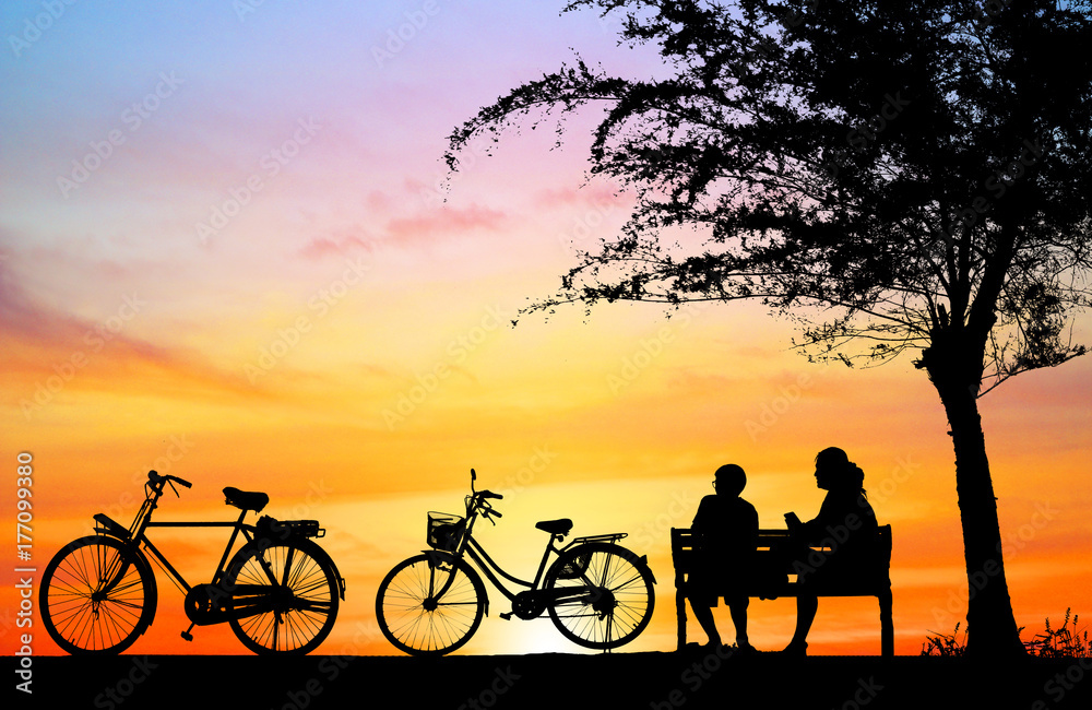 silhouette vintage bike and love couple in  the holiday on sunrise time