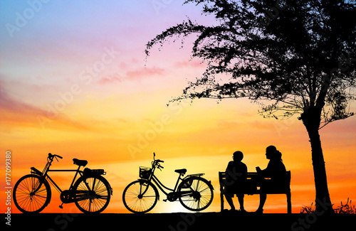 silhouette vintage bike and love couple in the holiday on sunrise time