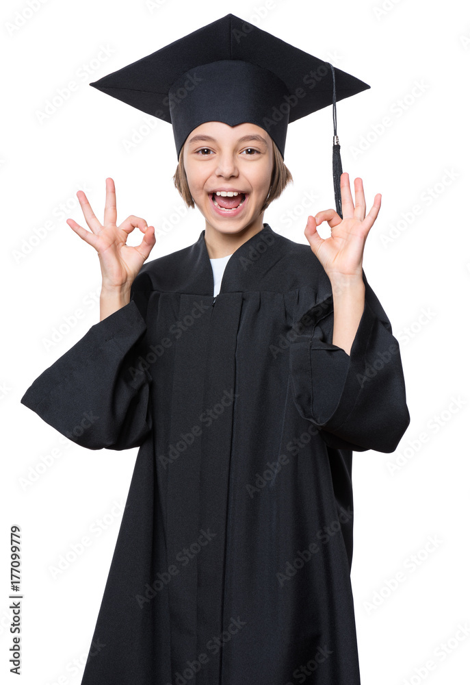 Graduate little happy girl student in black graduation gown with hat showing ok gesture - isolated on white background. Child back to school and educational concept. Graduate little happy girl student in black graduation gown with hat showing ok gesture - isolated on white background. Child back to school and educational concept.