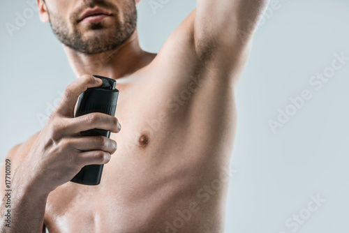 shirtless man spraying deodorant photo