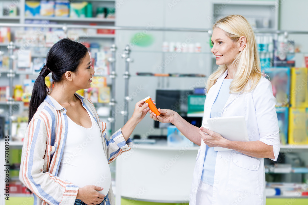 pharmacist giving pills to pregnant woman