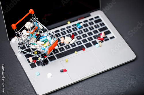 laptop and pills in small shopping trolley