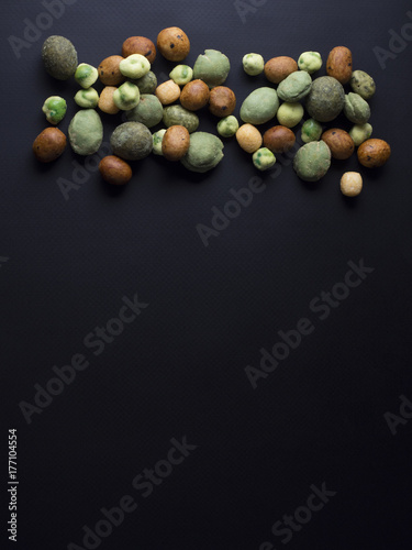 Japanese wasabi crackers in different colors isolated on black background