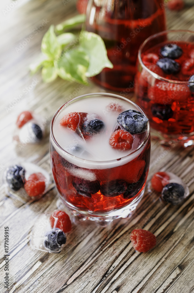 Summer berry lemonade with frozen berries on a wooden rustic table, selective focus Summer berry lemonade with frozen berries on a wooden rustic table, selective focus