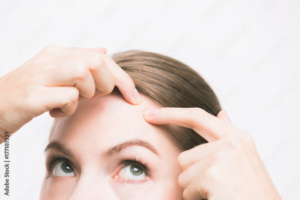 Fototapeta premium young woman squeezing a pimple. skincare concept.