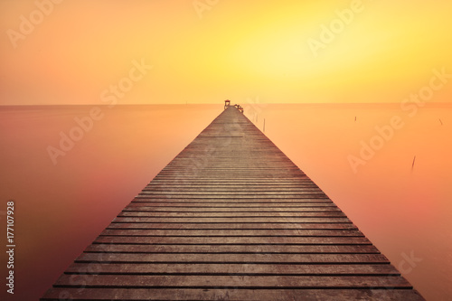 Wooden bridge in the beautiful view on sea at sunset
