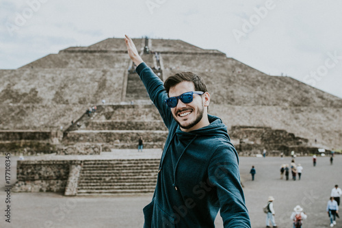 .Young carefree male tourist enjoying the pyramids of Teotihuacan in Mexico. Lifestyle portrait. photo