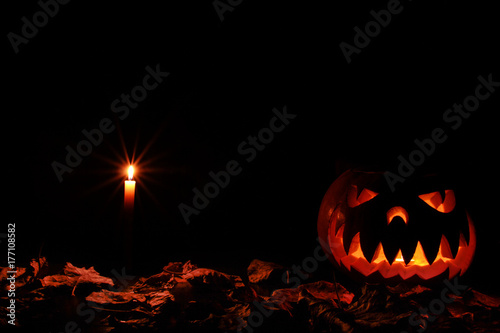 a terrible Halloween pumpkin glowing in the dark