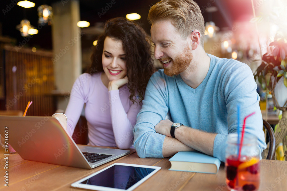 Happy couple spending time at coffee shop working on laptop Happy couple spending time at coffee shop working on laptop
