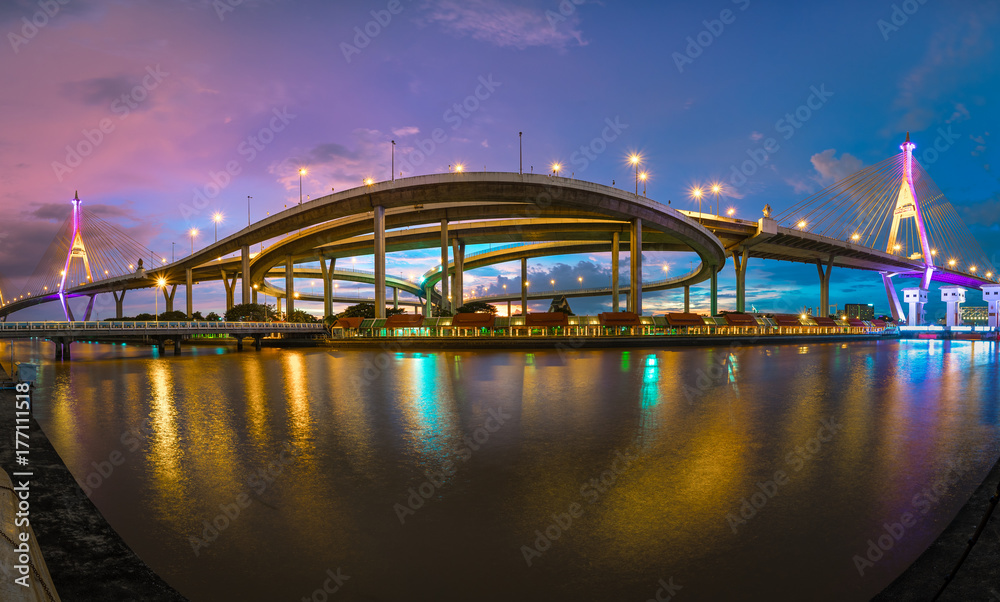 Panoramic view of Bhumibol Bridge, the Industrial Ring Road Bridge in the night scene after sunset. Twilight sky and light reflection on smooth water, Thailand