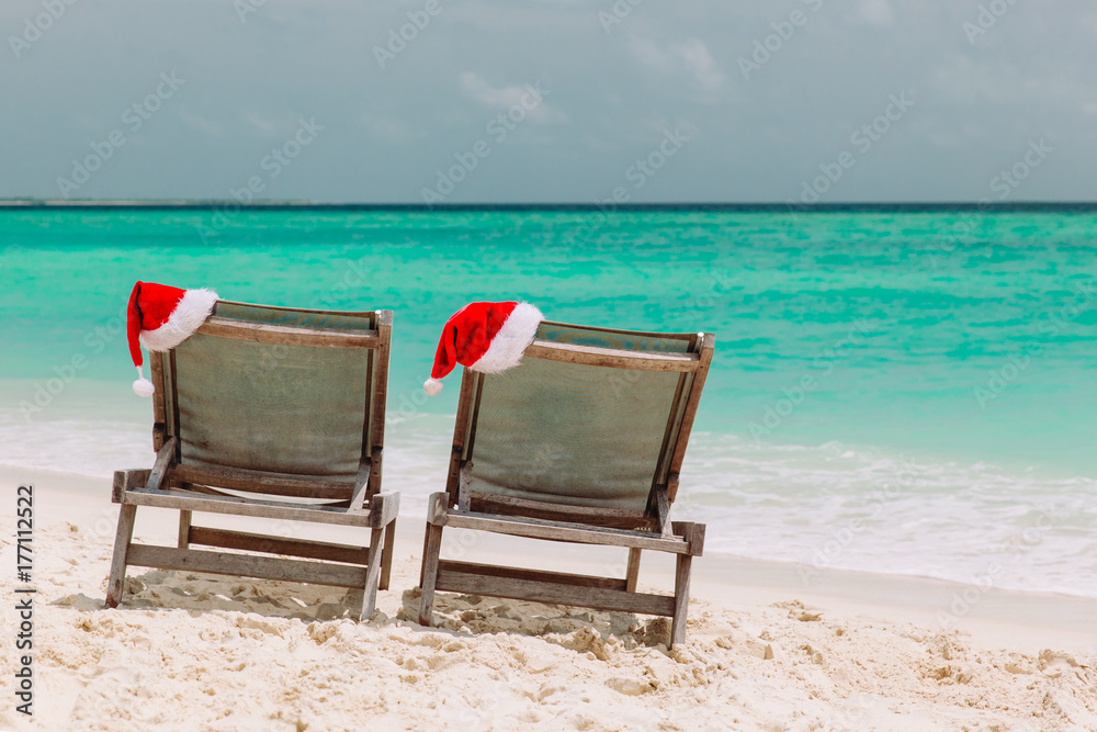 Christmas on beach -chair lounges with Santa hats at sea Christmas on beach -chair lounges with Santa hats at sea