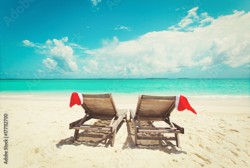 Christmas on beach -chair lounges with Santa hats at sea