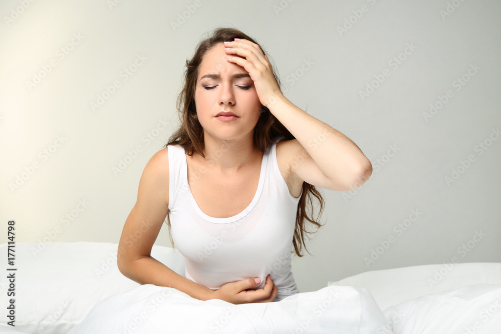 Sick young woman lying in white bed Sick young woman lying in white bed
