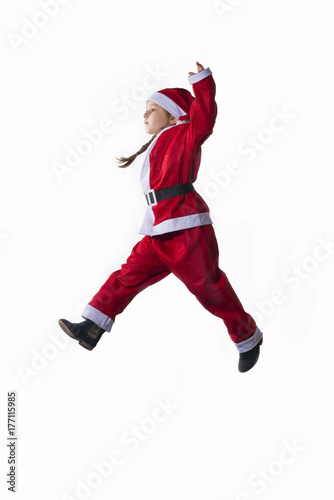 Little caucasian girl dressed as Santa Claus jumping on white background.