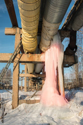 large pink icicle on a water pipe and loss of heat in winter