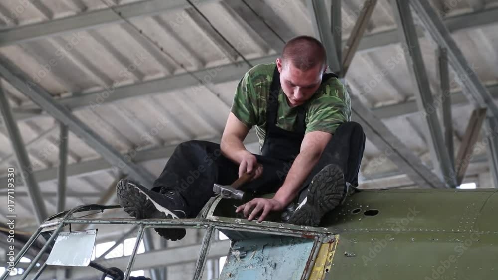 Workers repair the engine in the workshop. Workers repair the engine in the workshop.
