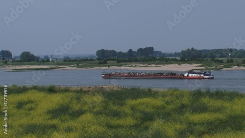 Cargo ship transporting metal scrap downstream the River Waal near Pannerden. The River Waal is a major river and the main distributary branch of river Rhine. THE NETHERLANDS - JULY 2015:  photo