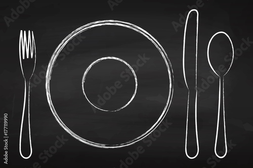 Cutlery on the chalkboard. Fork, knife and spoon. Plate. For your design.