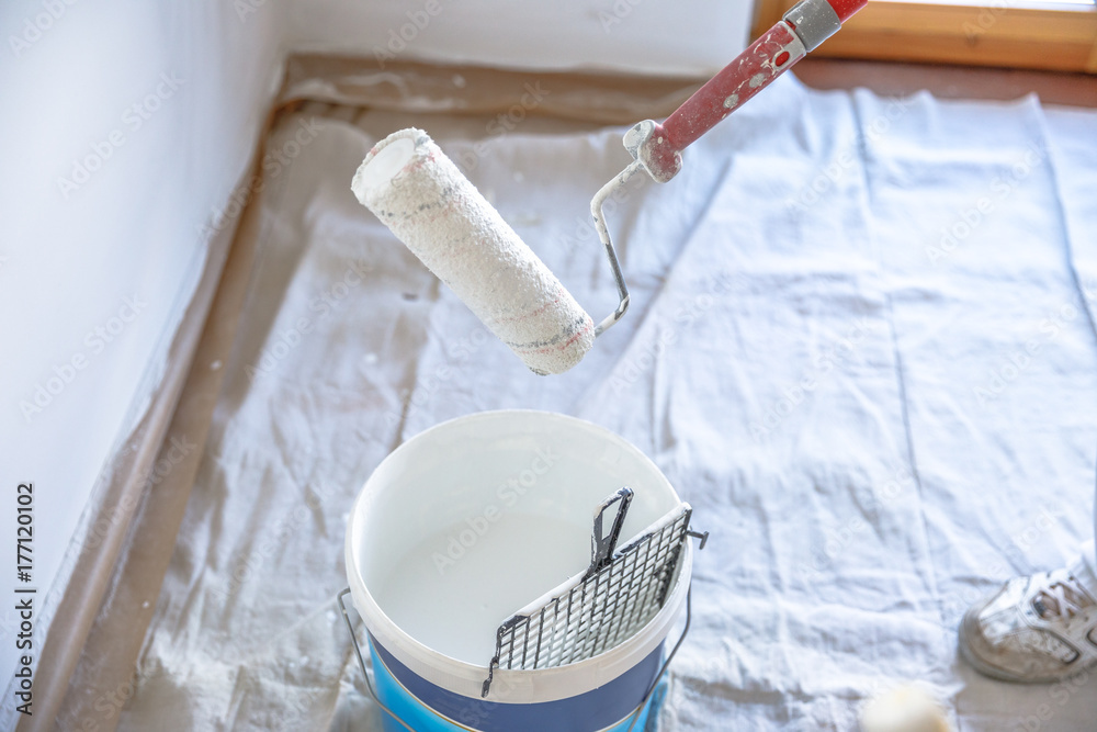 Ταπετσαρία Close up of draining paint roller in bucket in renovation room with whitewasher