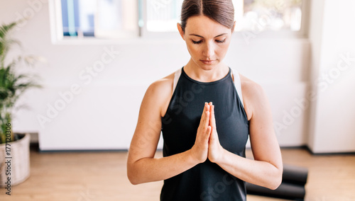 Young woman in namaste yoga pose