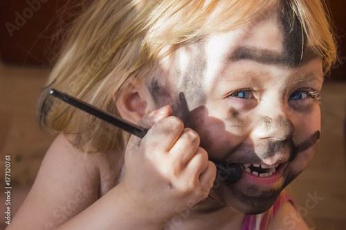 little girl went too far with make-up, first make-up. photo