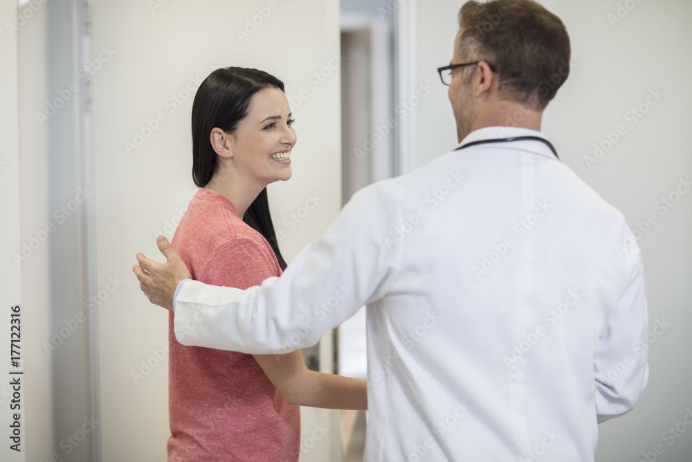 Doctor shaking hands with patient in medical practice Doctor shaking hands with patient in medical practice