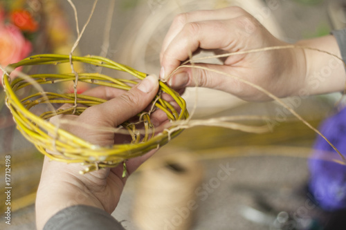Flourist weaving a basket for flower arrangent photo