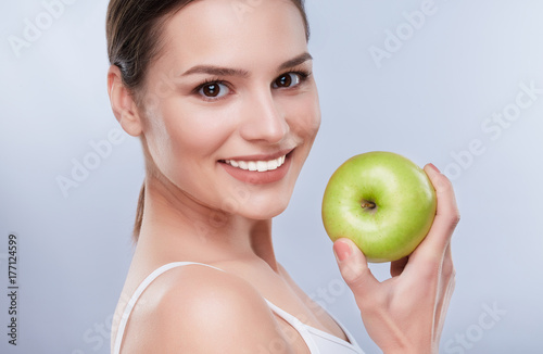 Closeup of smiling woman with green apple