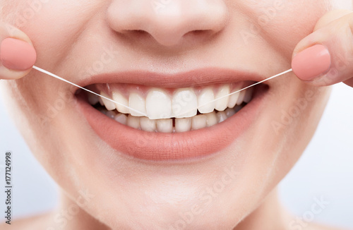 Cleaning white teeth with tooth thread